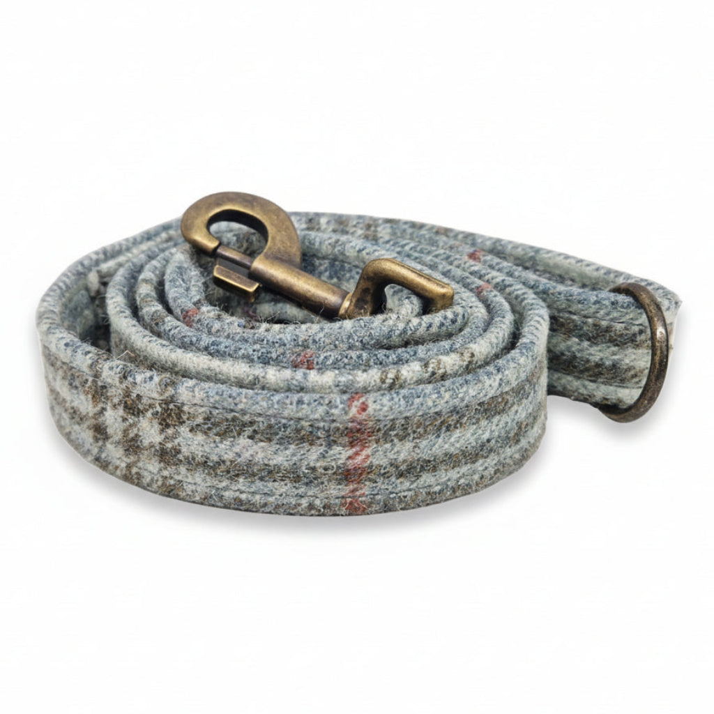 Dog leash with a textured tweed pattern and brass snap hook on a white background