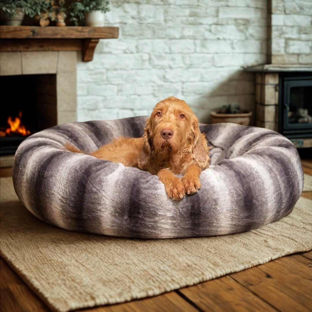Dog resting comfortably in a soft round donut dog bed with raised sides
