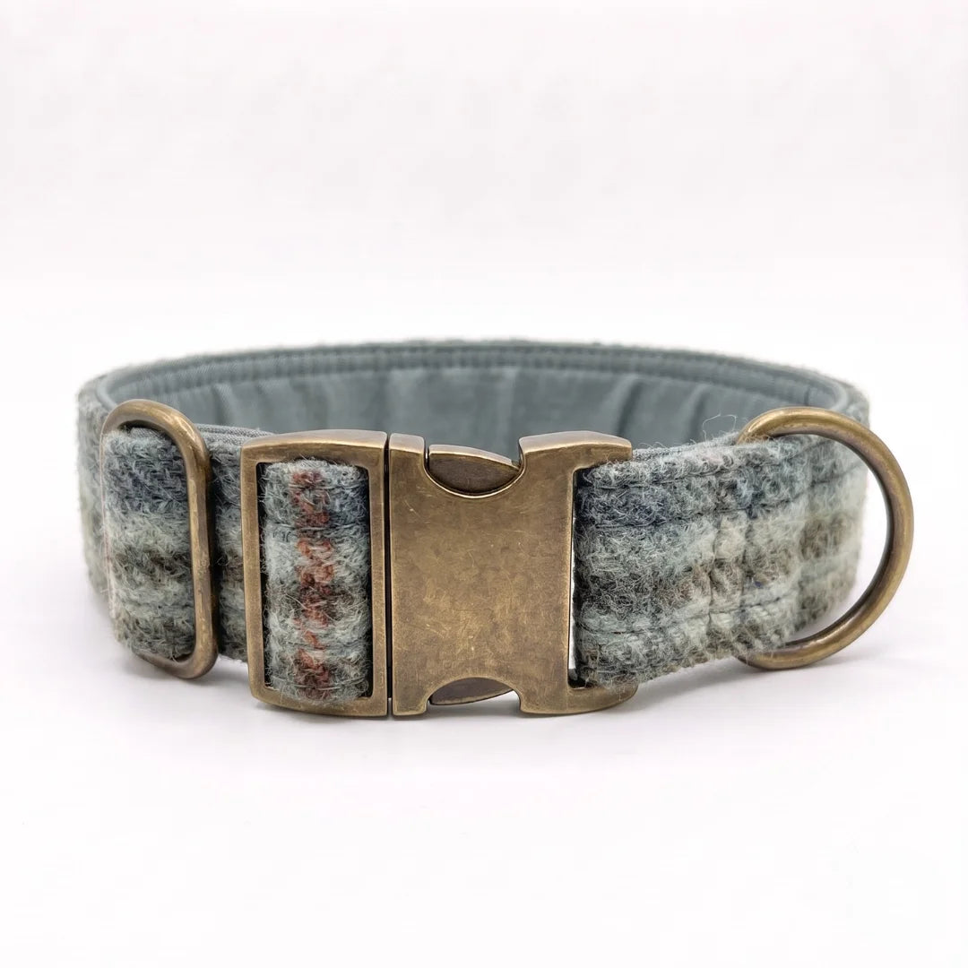 A woven abraham moon wool dog collar in a heathered blue and gray pattern with a distressed bronze metal buckle and a brass ring, shown on a white background.