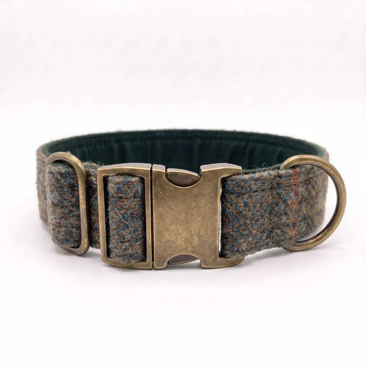 A woven tweed dog collar in a blue, brown, and gray pattern with a dark green interior and antique bronze metal hardware, including a buckle, D-ring, and keeper.