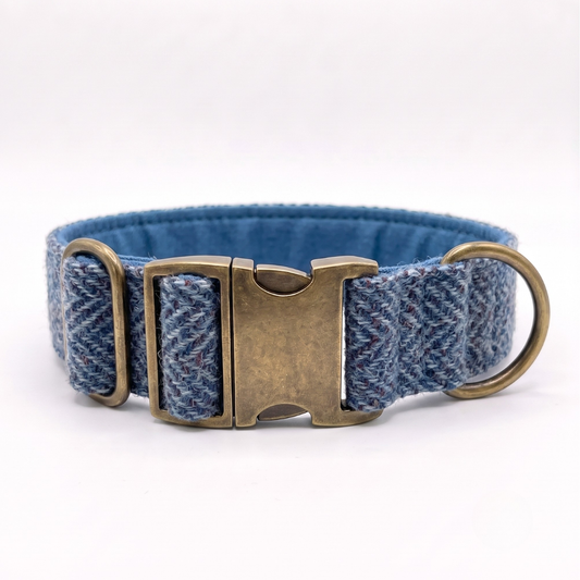 A blue herringbone-patterned fabric dog collar  extra wide with an antique bronze metal buckle and a brass ring, shown on a white background.