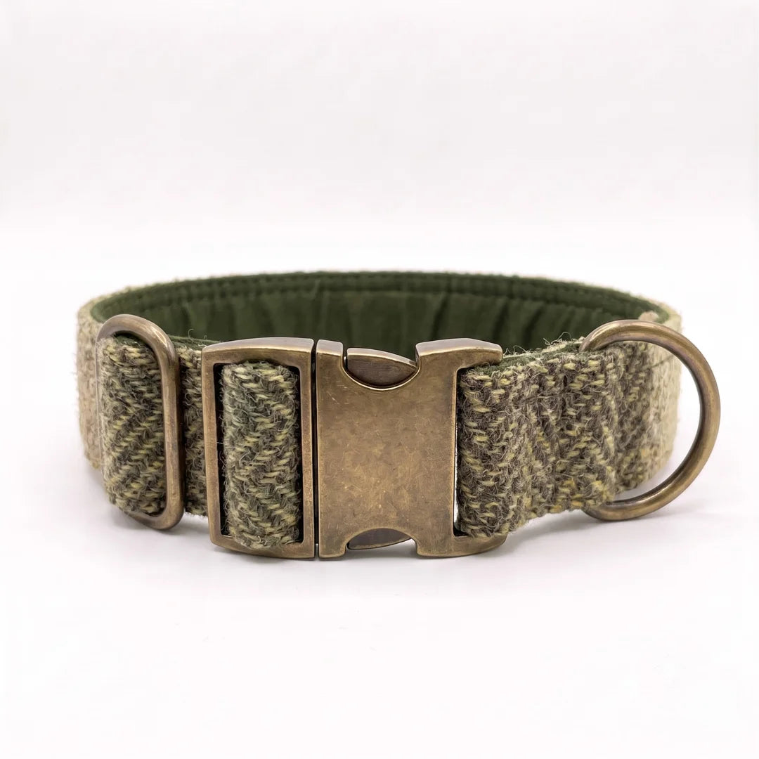 A harris tweed 38mm wide dog collar in a green and brown houndstooth pattern with an antique bronze metal buckle and a matching metal ring, shown on a white background.