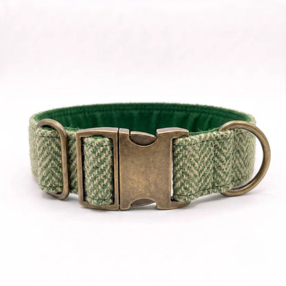 A green and beige herringbone patterned dog collar with a dark green cotton lining and an antique bronze metal buckle and rings, shown on a plain white background.