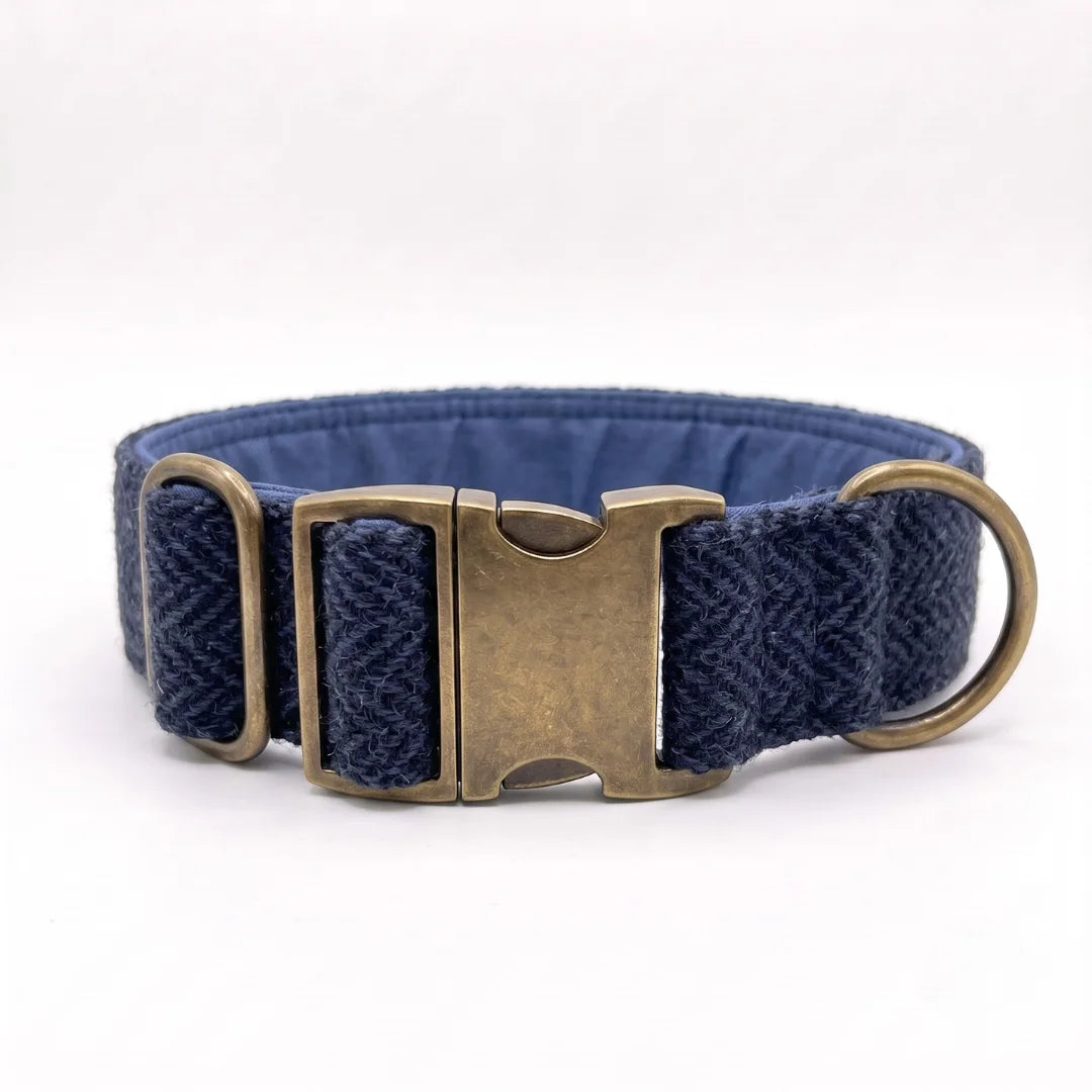 A navy blue woven harris tweed dog collar with a textured herringbone pattern and antique bronze metal hardware, including a buckle and D-ring, shown on a white background.