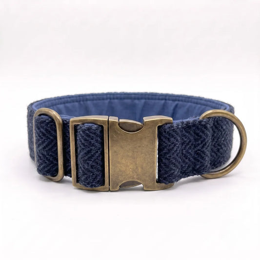 A navy blue woven harris tweed dog collar with a textured herringbone pattern and antique bronze metal hardware, including a buckle and D-ring, shown on a white background.