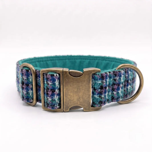 A harris tweed dog collar with a textured pattern of teal, blue, and purple threads, featuring an antique bronze buckle and a matching metal ring, shown on a white background.