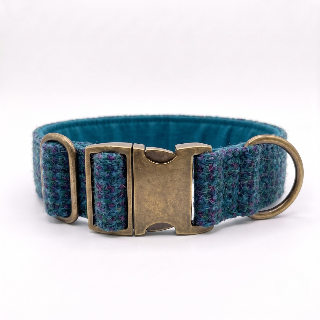 A woven dog collar in a heathered teal blue and purple pattern, featuring an antique bronze metal buckle and a brass D-ring, shown on a white background.