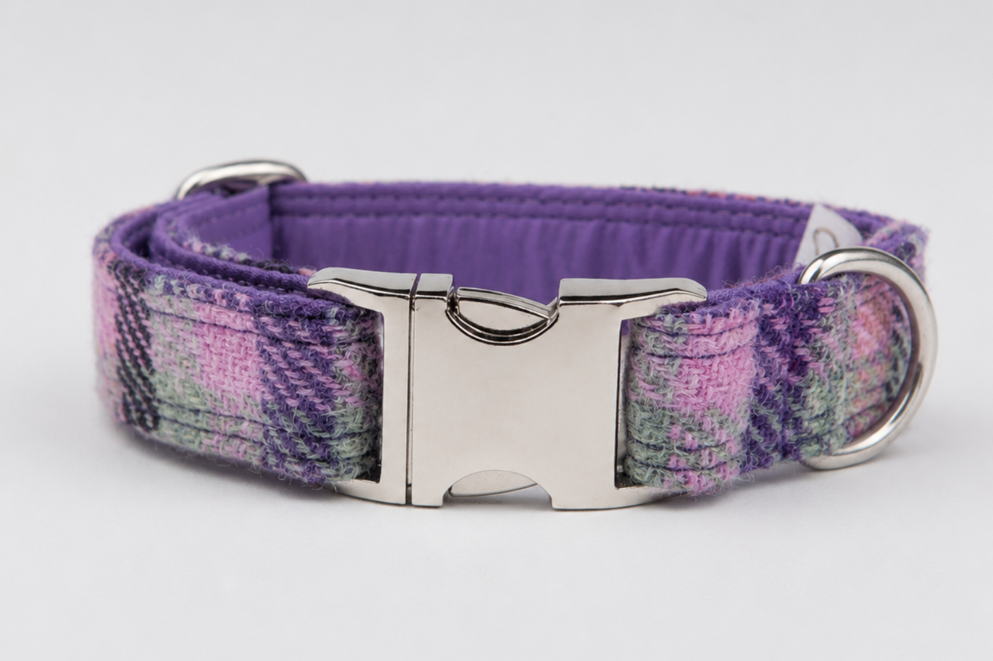 A purple plaid dog collar with a silver metal quick-release buckle and D-ring, shown on a light gray background.