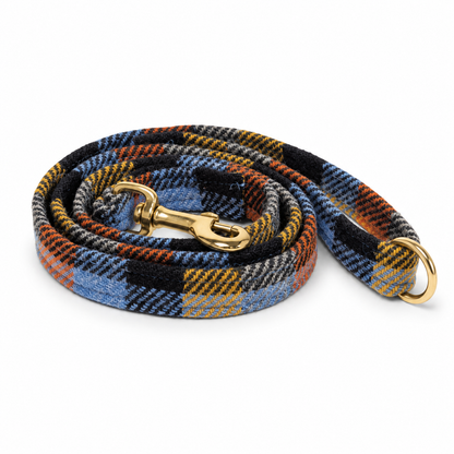 A plaid tweed lead rope with a blue, black, orange, and gray pattern, featuring gold-tone metal hardware including a snap hook and ring, shown on a white background.