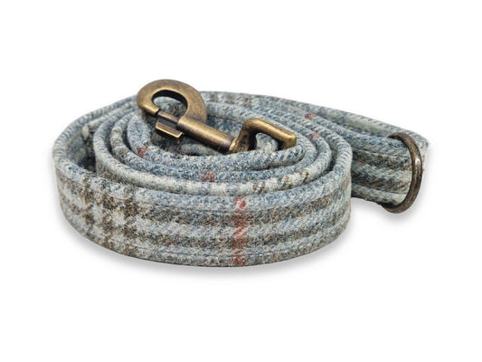 Dog leash with a textured tweed pattern and brass snap hook on a white background
