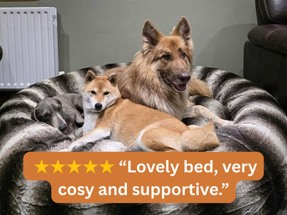 Brown Donut Dog Bed with three dogs resting and customer review overlay: Lovely bed, very cosy and supportive.