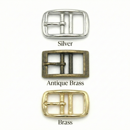 Three belt buckles in silver, antique brass, and brass on a white background