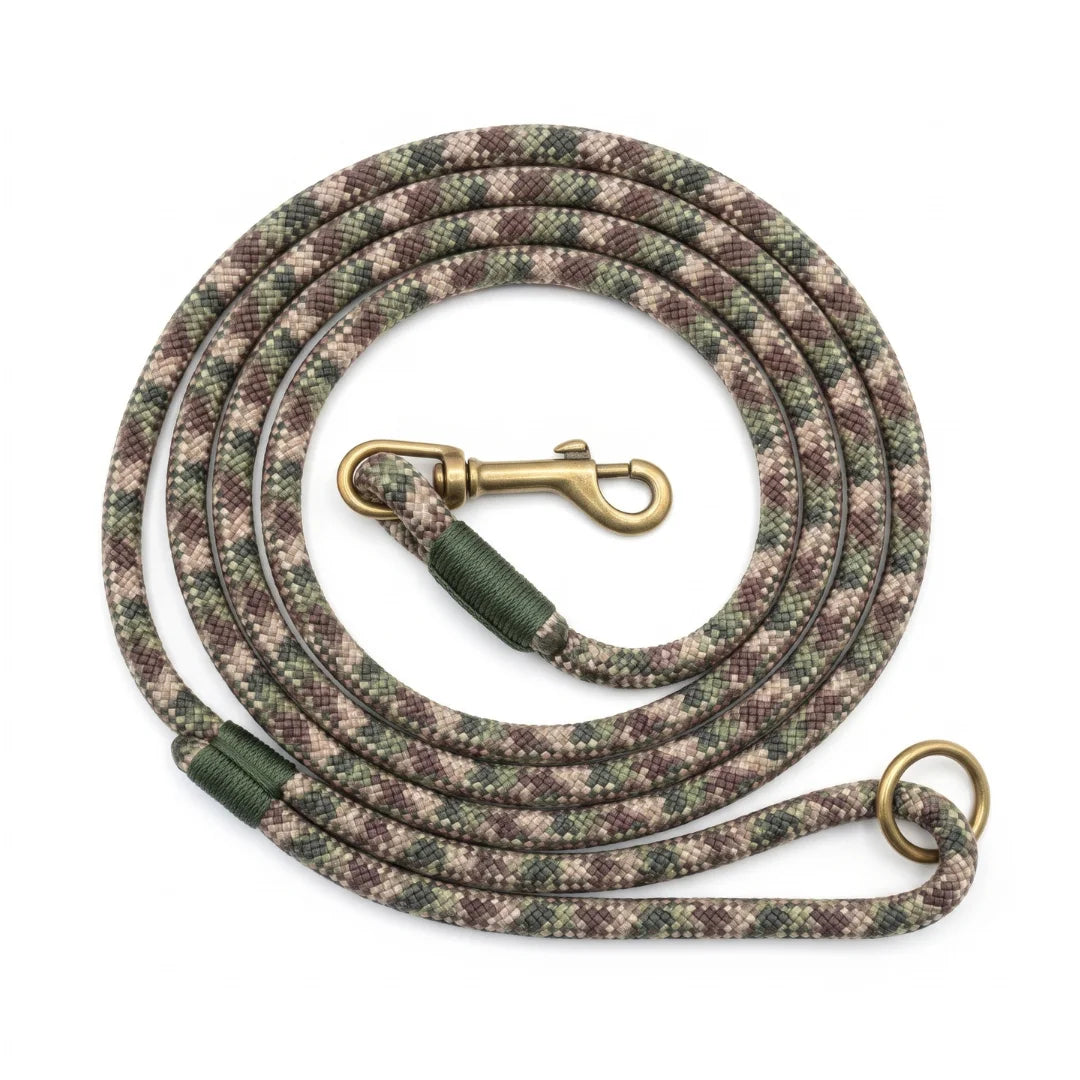 A coiled dog leash with a camouflage pattern in green, brown, and beige, featuring a brass clasp and a matching brass ring, set against a plain white background.