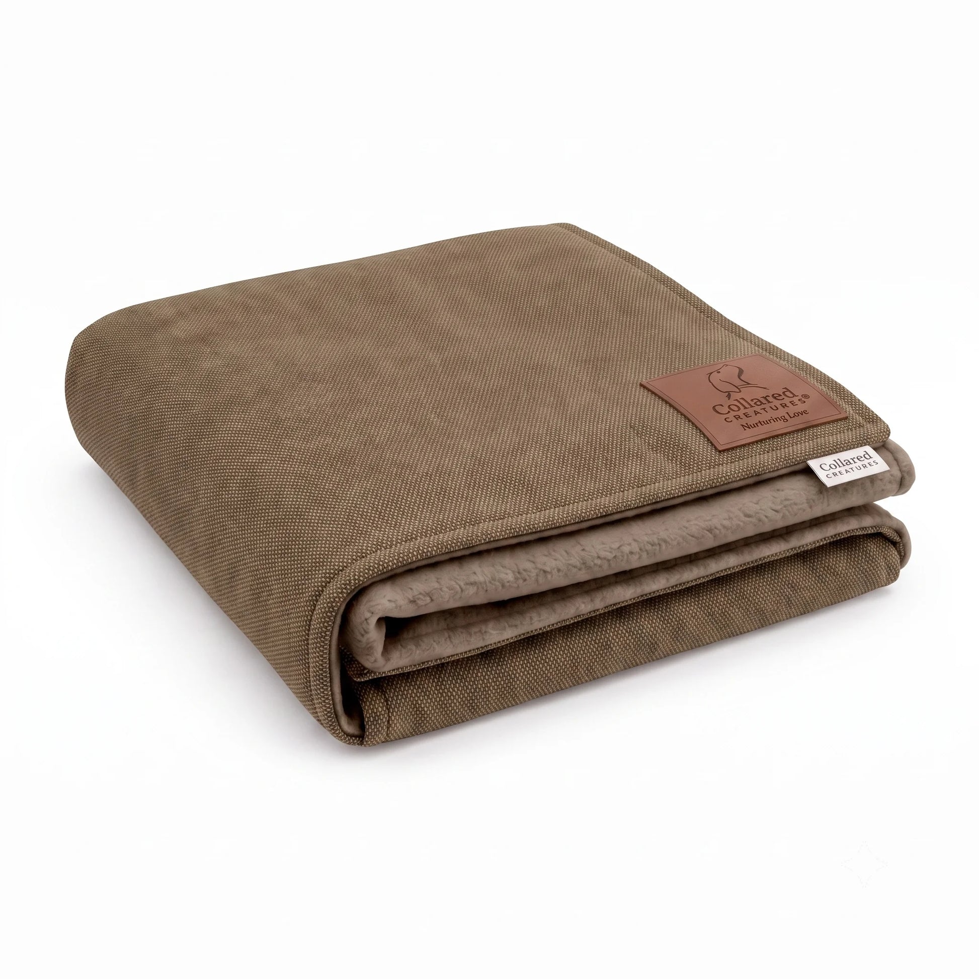 Collared Creatures taupe mocha woven dog blanket, folded to show soft taupe fleece lining and brown leather Nurturing Love patch