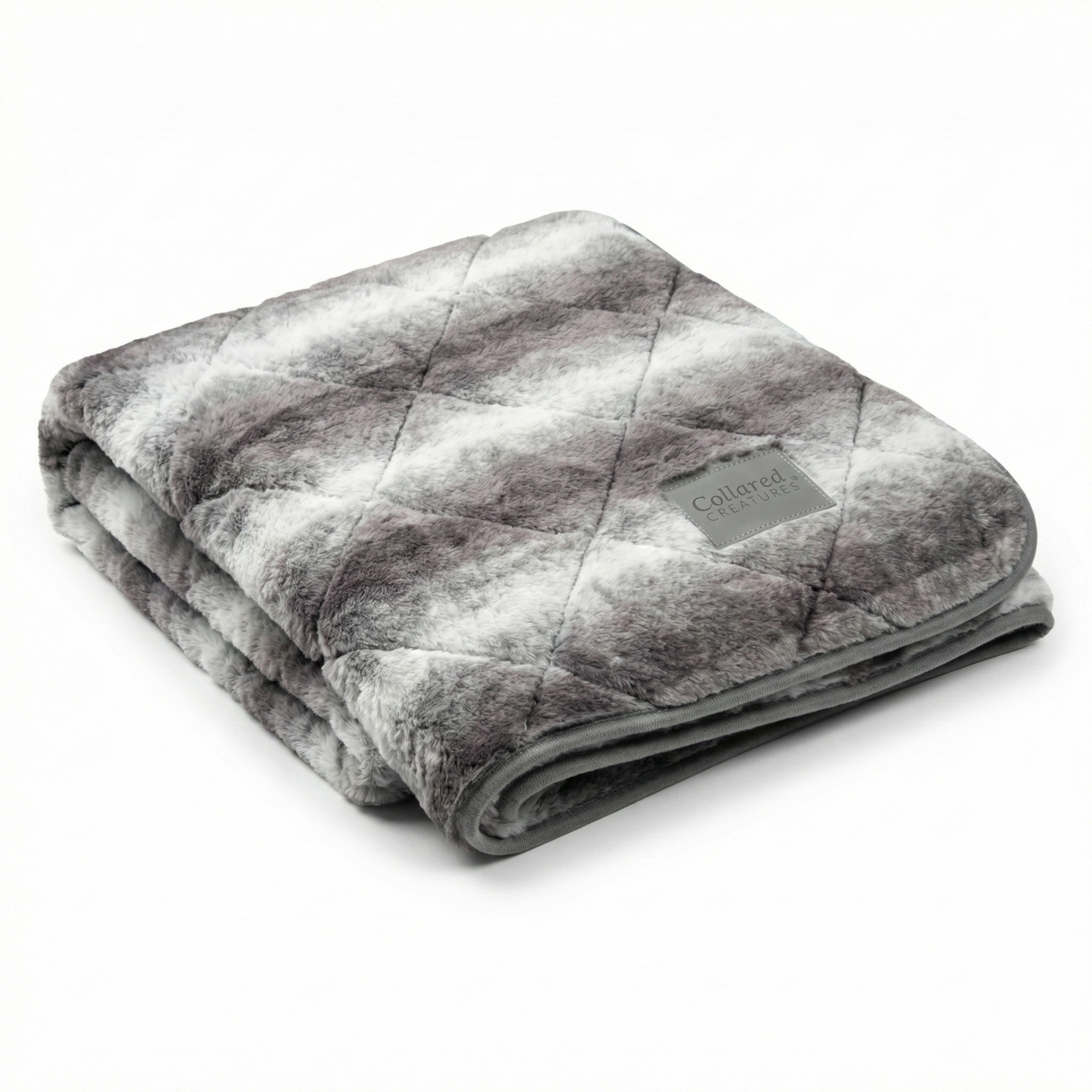 Folded gray patterned blanket with a brand label on a white background