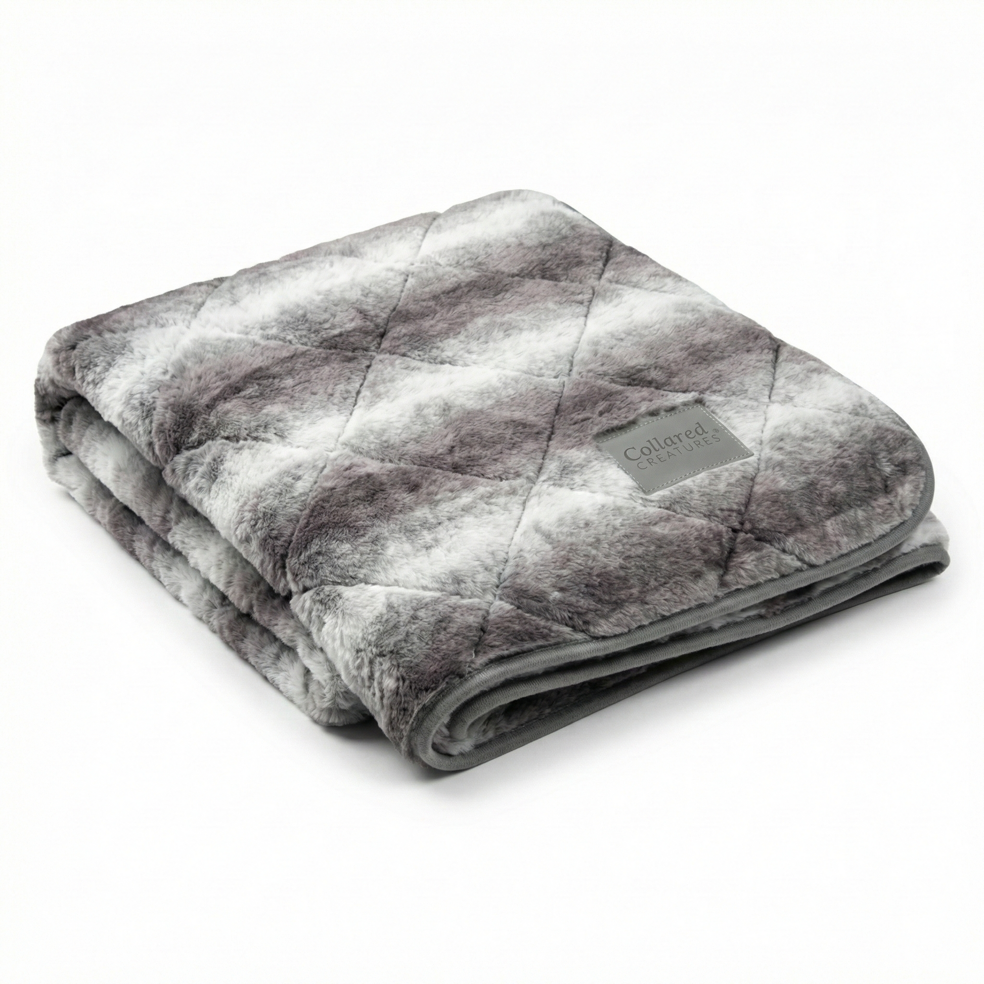 Folded gray patterned blanket with a brand label on a white background