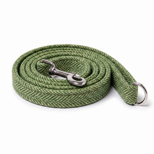 An olive green herringbone patterned tweed dog leash with a silver metal snap hook and a silver metal ring, coiled on a white background.