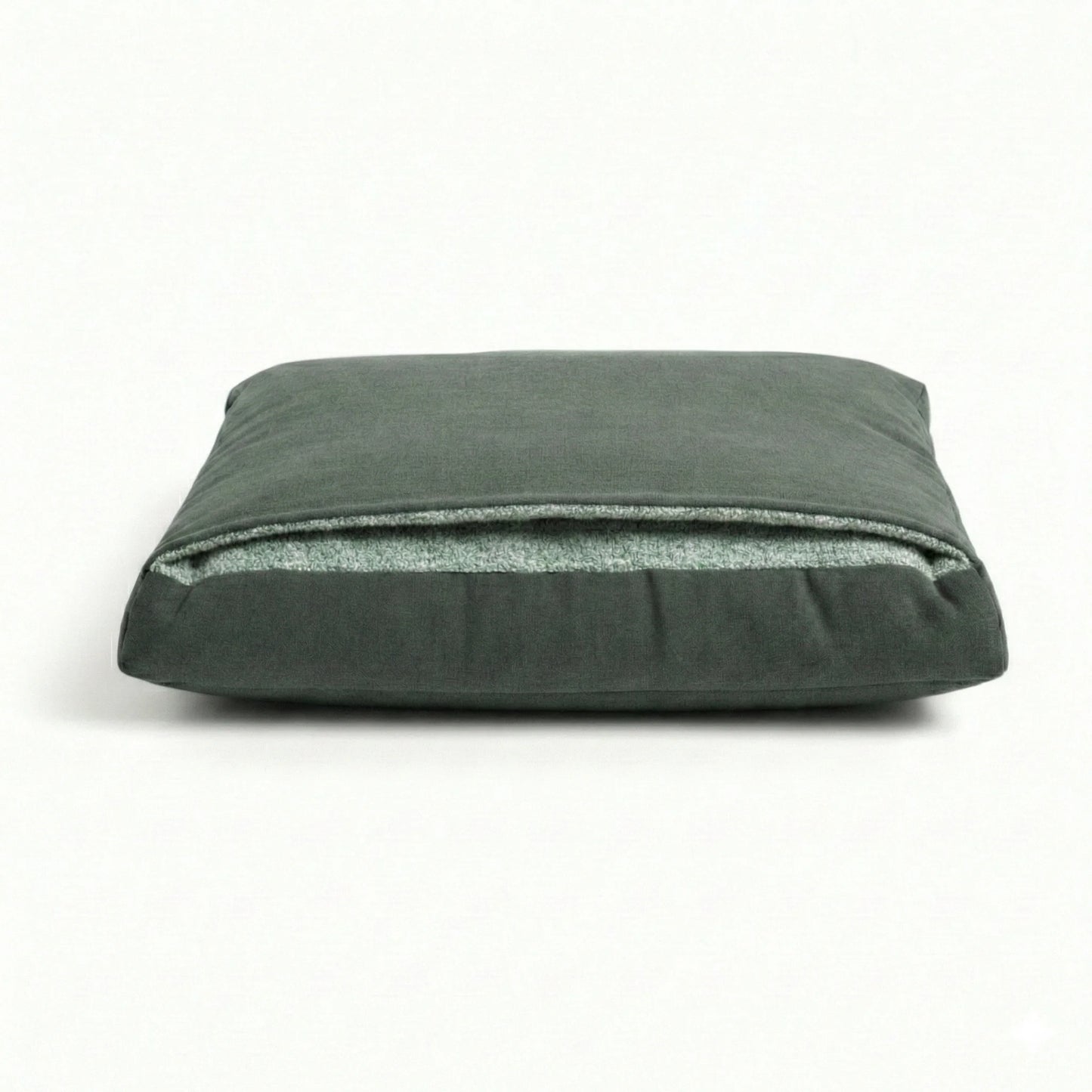 Green pillow dog bed with attached hood on a white background
