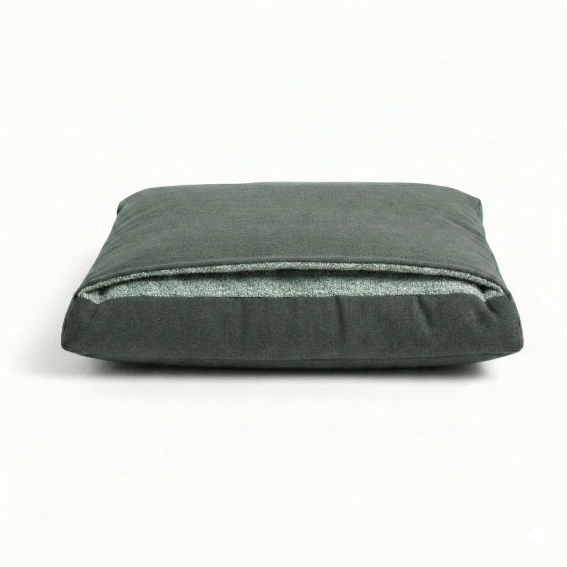 Green pillow dog bed with attached hood on a white background