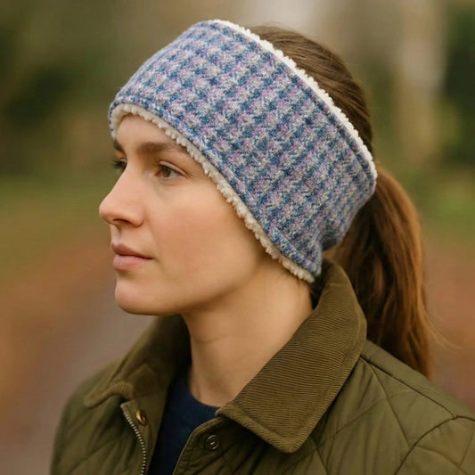 Person wearing a blue check tweed headband with a blurred natural background