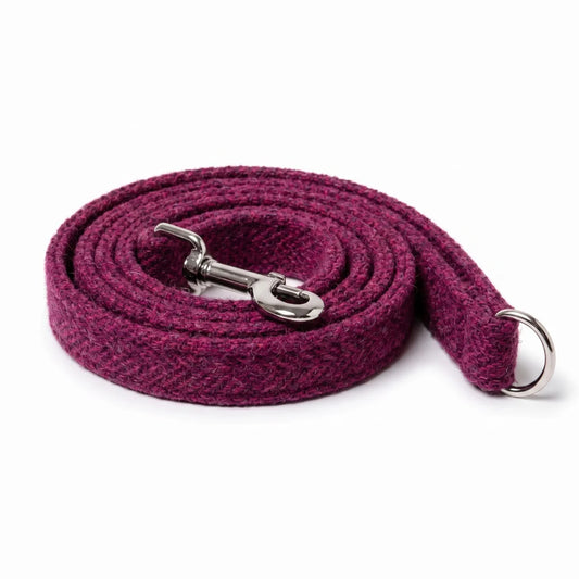 A coiled burgundy wool-fiber dog leash with a silver metal snap hook and D-ring, displayed on a clean white background.