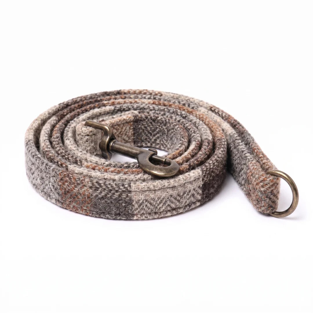 A woven horse lead rope with a herringbone pattern in gray, brown, and beige, featuring an antique bronze metal snap hook and a matching ring, coiled on a white background.