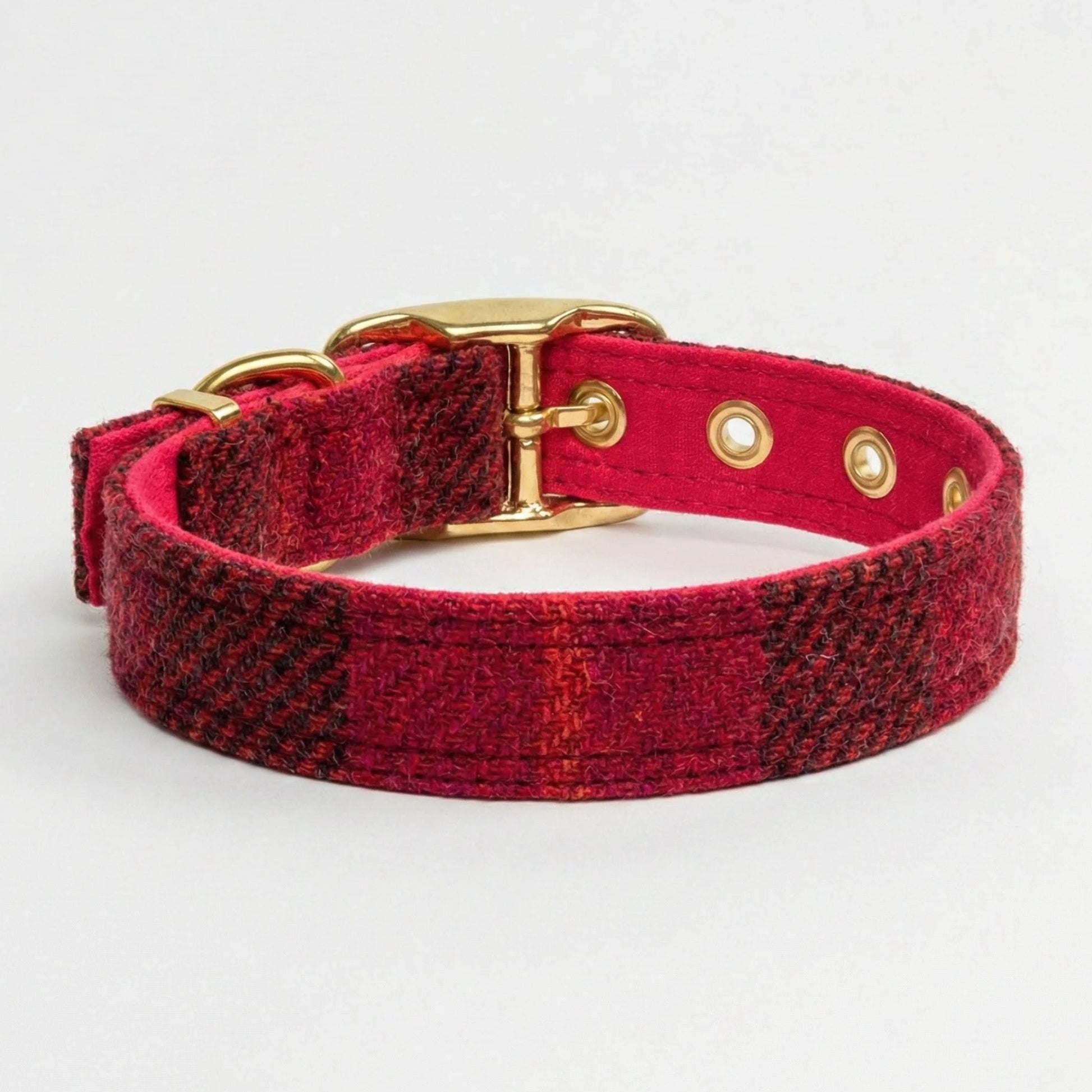 Red plaid dog collar with gold hardware on a light gray background