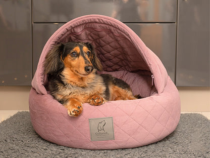 Dachshund relaxing in a Dusky Pink Quilted Velour Cocoon Dog Bed by Collared Creatures