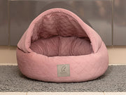Studio photo of Dusky Pink Quilted Cocoon Dog Bed with structured hood and logo badge - Collared Creatures
