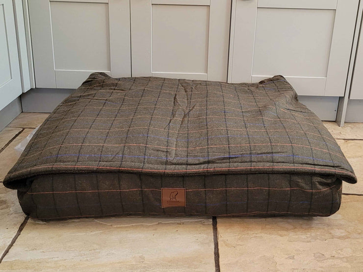 Green Tweed Dog Snuggle Bed neatly arranged in a modern kitchen