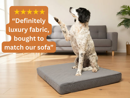 Black and white dog sitting on a grey quilted mattress dog bed with a five-star customer review overlay