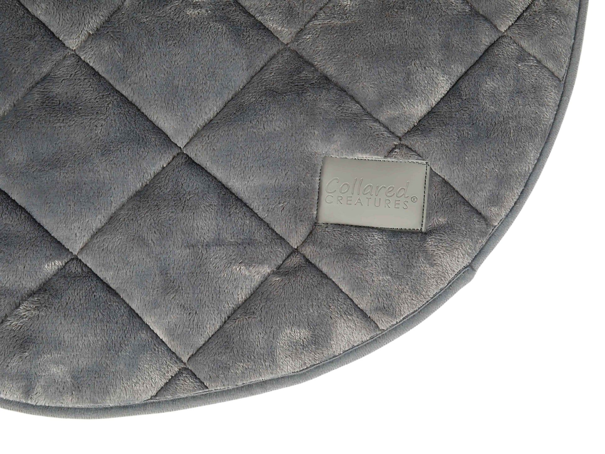 Close-up of grey faux fur dog blanket showing quilted texture and Collared Creatures logo