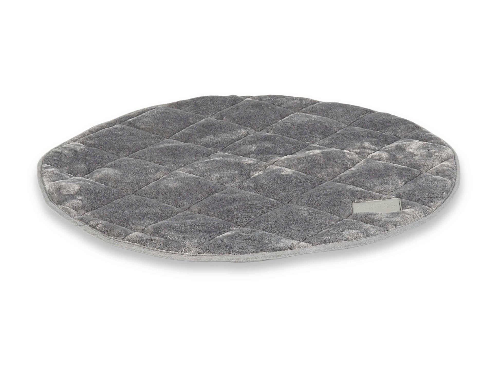 Angled view of grey quilted round dog mat with soft plush finish and piped edges