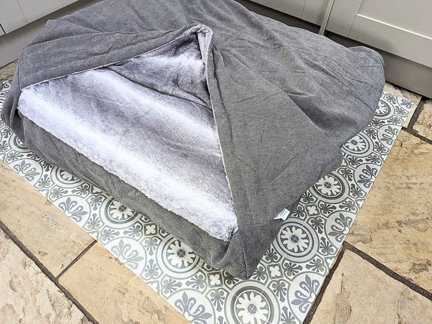 Grey snuggle bed with faux fur inner, styled in kitchen setting - Collared Creatures