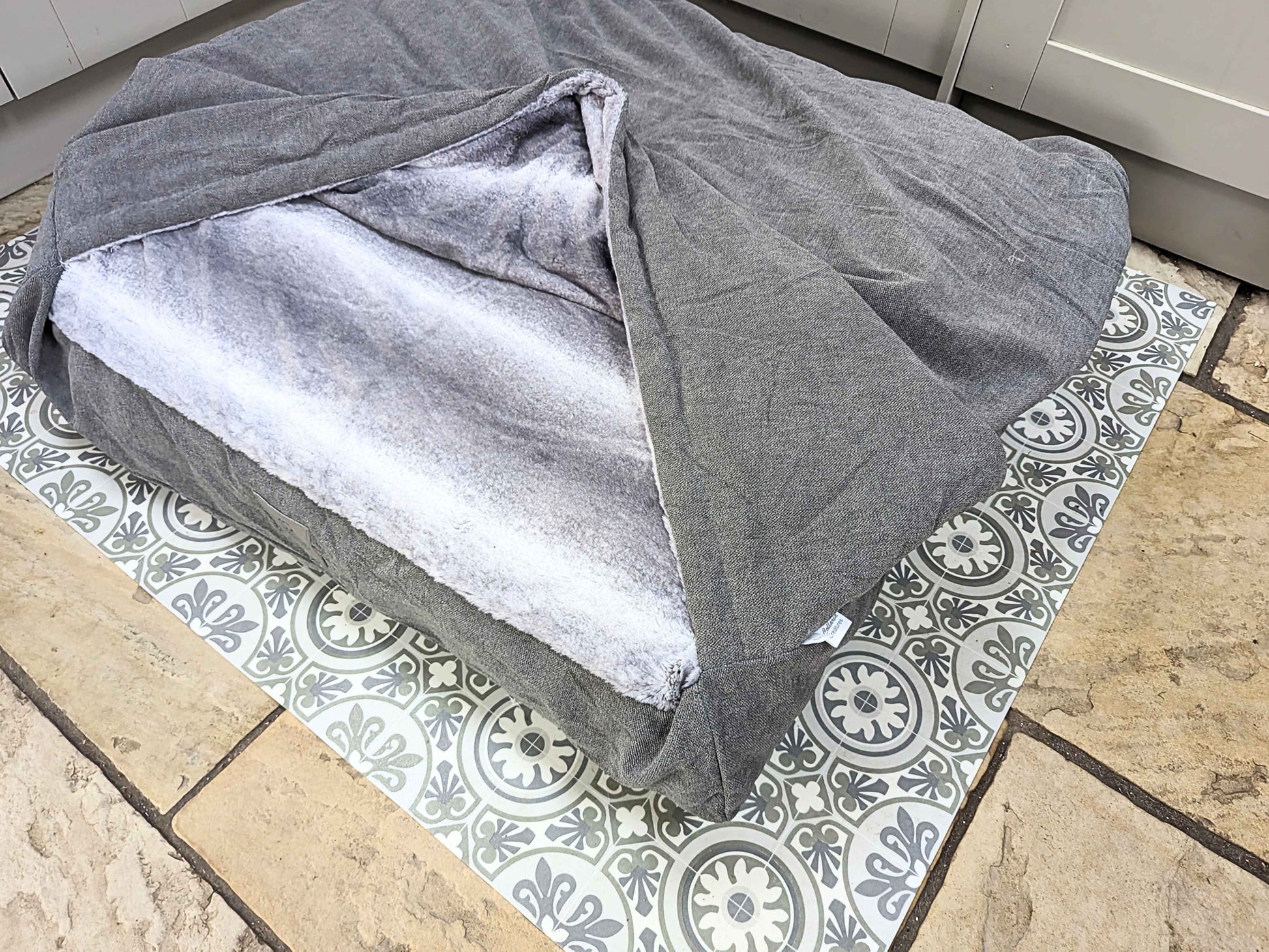 Grey snuggle bed with faux fur inner, styled in kitchen setting - Collared Creatures