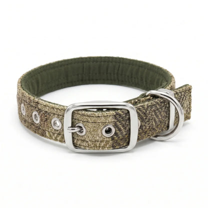 A dog collar with a harris tweed green block herringbone pattern, featuring a silver-tone metal buckle, D-ring, and eyelets, shown on a white background.