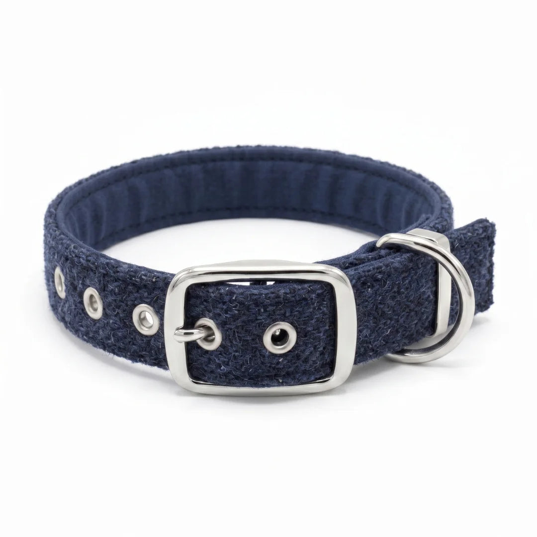 A navy blue herringbone textured fabric dog collar with a silver-tone metal buckle, D-ring, and eyelets, shown on a plain white background.