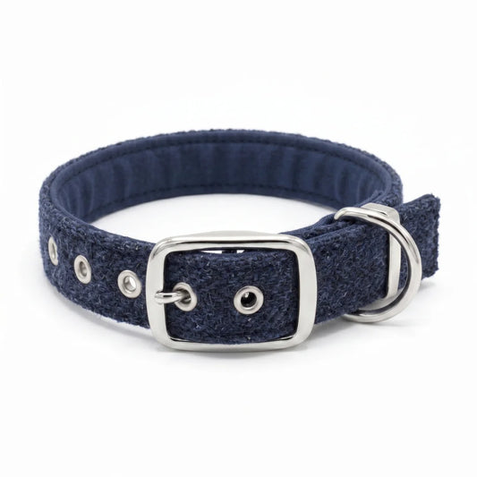 A navy blue herringbone textured fabric dog collar with a silver-tone metal buckle, D-ring, and eyelets, shown on a plain white background.