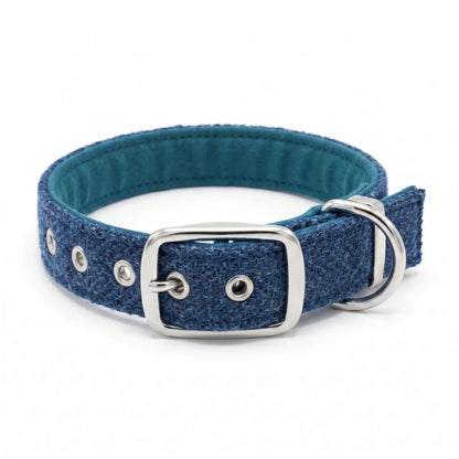 A blue textured harris tweed dog collar with a teal blue padded inner lining, silver-tone metal buckle, and D-ring, shown on a clean white background.