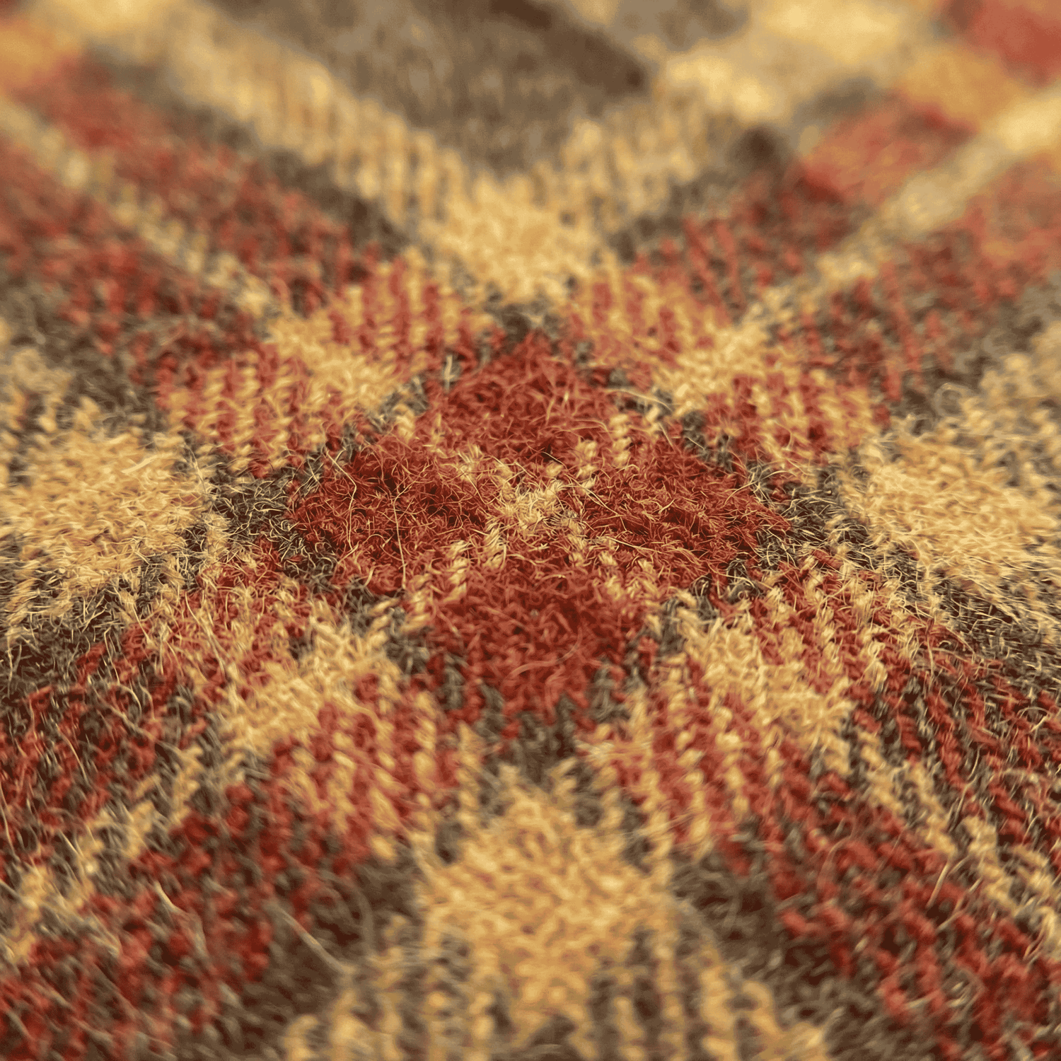 Close up of authentic Harris Tweed fabric showing hand-woven wool weave texture in red gold and brown tartan
