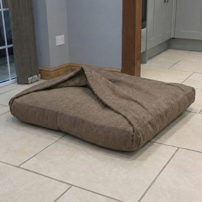 Brown covered pet bed on a tiled floor in a room with gray walls and wooden furniture.