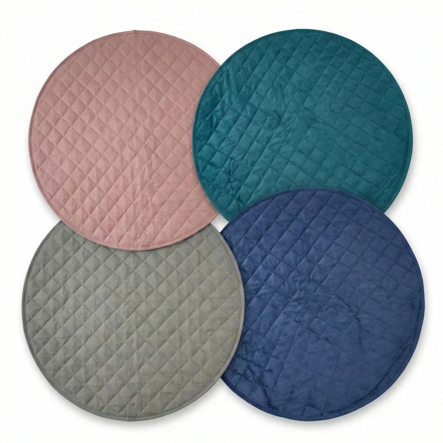 Four round quilted dog mats in pink, teal, gray, and blue on a white background.