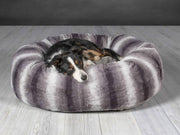 Border Collie sleeping in a luxury grey faux fur donut dog bed