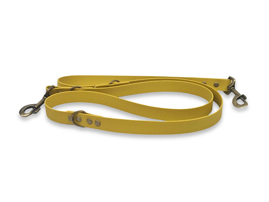 Yellow dog training leash with metal clasps on a white background