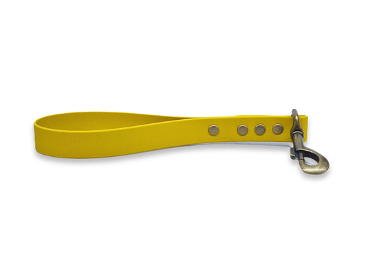 Yellow dog traffic handle with metal clip on a white background