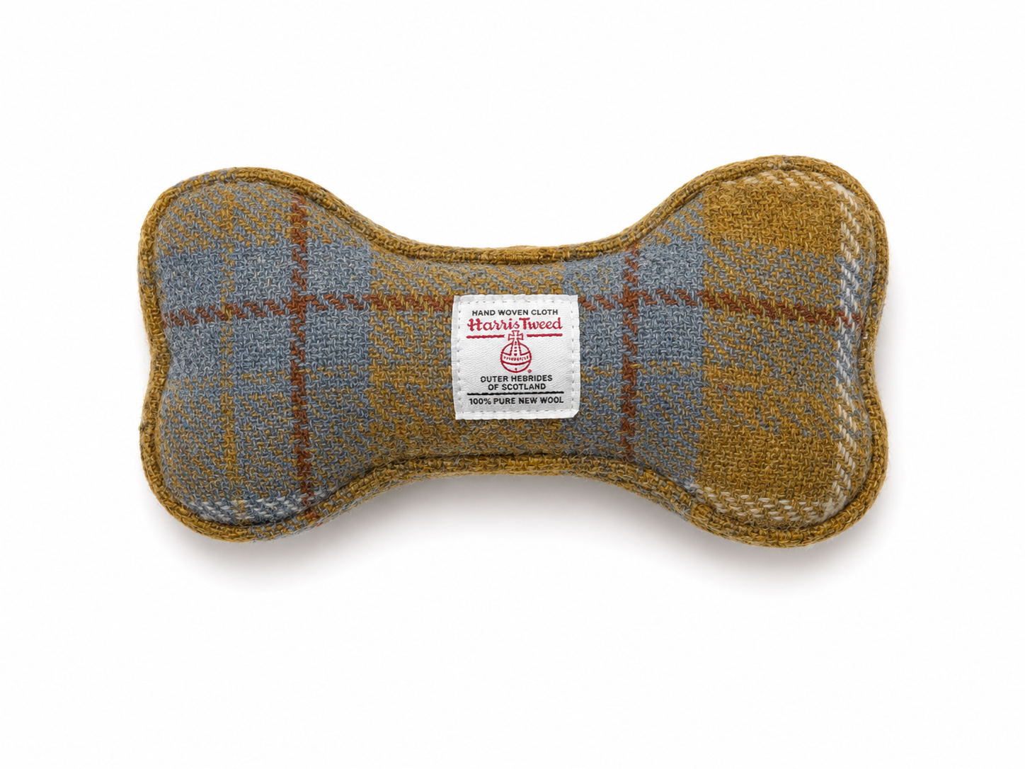 A bone-shaped dog toy made of Harris Tweed wool, featuring a plaid pattern in mustard yellow, slate blue, and brown, with a white brand label in the center.