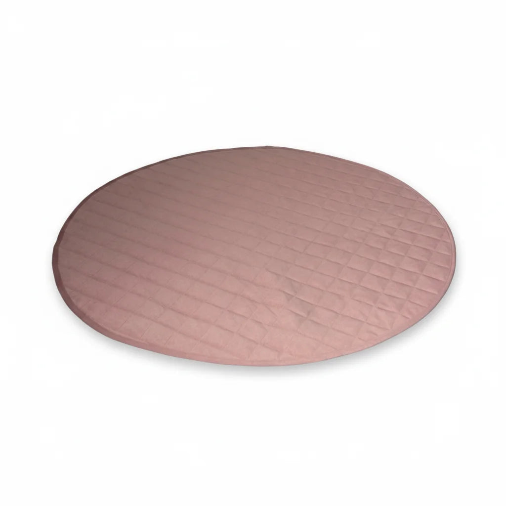 Round pink quilted dog mat on a white background