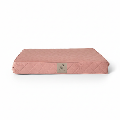 Pink quilted pet bed with a brand logo on a white background