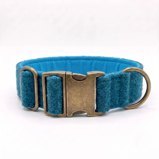A blue textured tweed dog collar with an antique bronze metal clasp and a matching metal ring, shown on a plain white background.