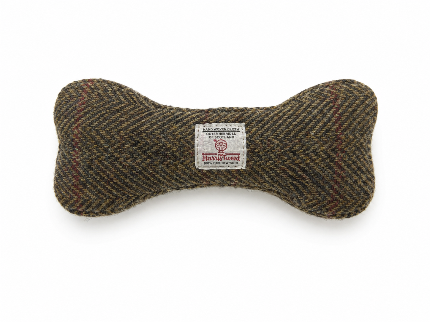 A bone-shaped dog toy made of textured herringbone tweed in brown, beige, and black, featuring a white sewn-in label from the brand Harris tweed.